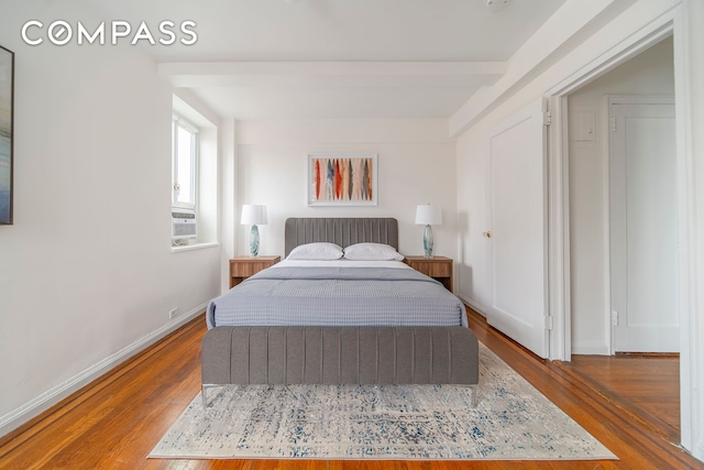 bedroom featuring wood finished floors and baseboards