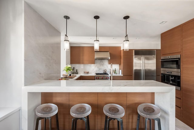 kitchen featuring stainless steel appliances, modern cabinets, range hood, and brown cabinets