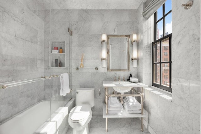 full bathroom with toilet, tile walls, shower / bath combination with glass door, and vanity
