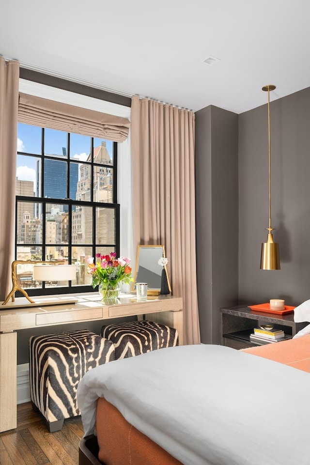 bedroom featuring a view of city and wood finished floors