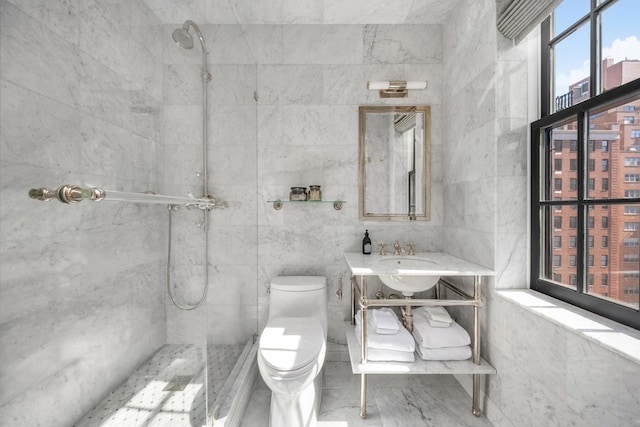 full bath featuring tile walls, tiled shower, toilet, and vanity