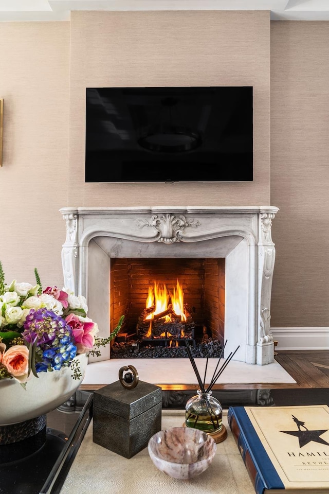 interior details with a high end fireplace, wood finished floors, and baseboards