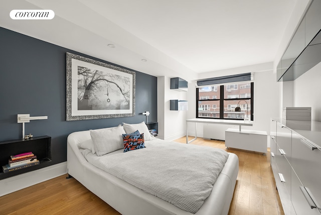 bedroom featuring light wood finished floors and baseboards