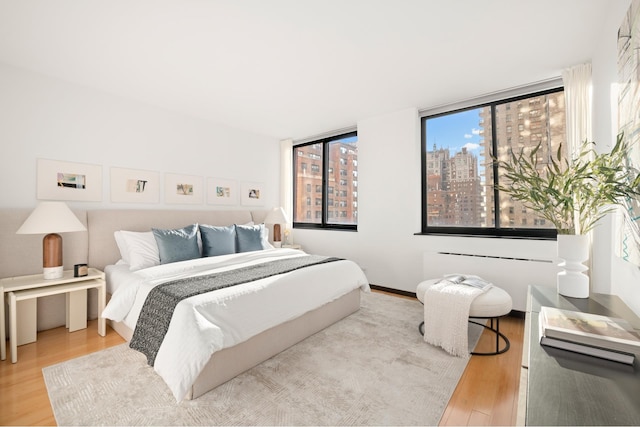 bedroom with wood finished floors and a city view