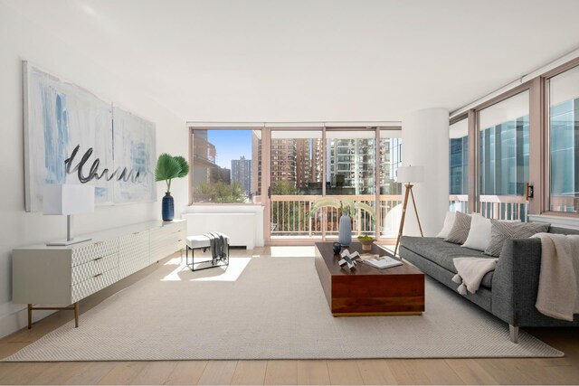 235 E 40th St Unit 6B, New York City, NY 10016 - living room with hardwood / wood-style floors, expansive windows, and a city view