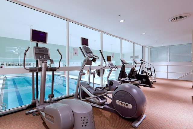gym featuring carpet, a wall of windows, and recessed lighting