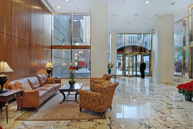 235 E 40th St Unit 6B, New York City, NY 10016 - building lobby featuring a high ceiling, recessed lighting, and expansive windows
