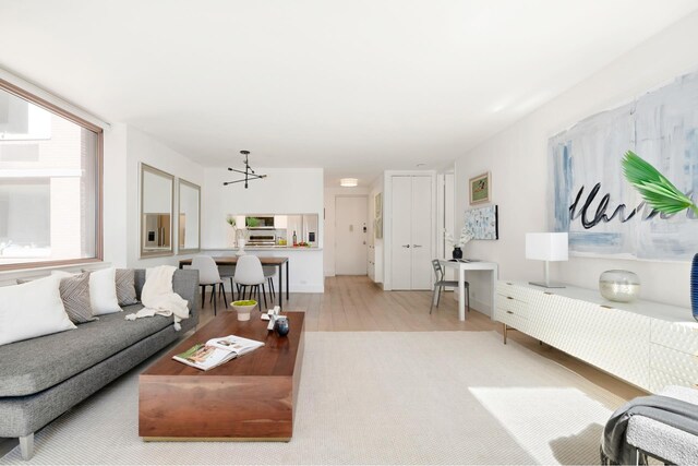 235 E 40th St Unit 6B, New York City, NY 10016 - living area featuring light wood-style floors and a chandelier