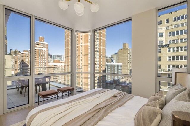 bedroom featuring expansive windows, a view of city, and wood finished floors