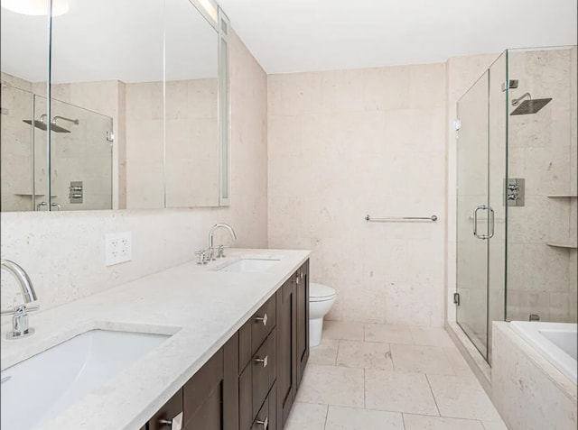 bathroom with a shower stall, a tub to relax in, double vanity, and a sink