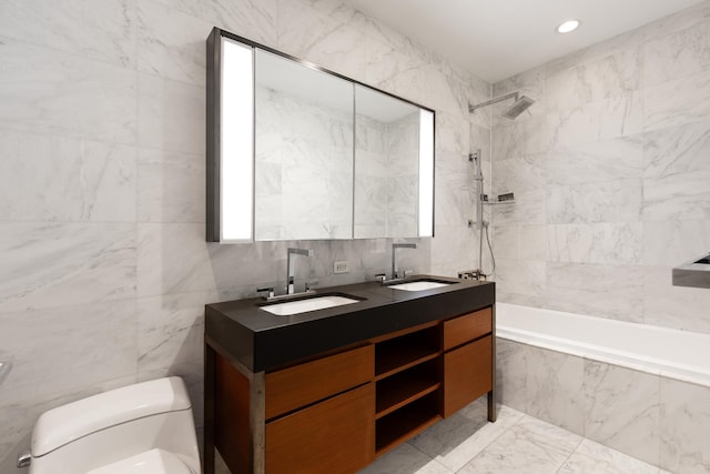 full bathroom featuring tile walls, double vanity, a sink, and toilet