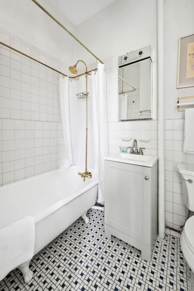 bathroom featuring vanity, toilet, tile patterned floors, shower / bath combination with curtain, and tile walls