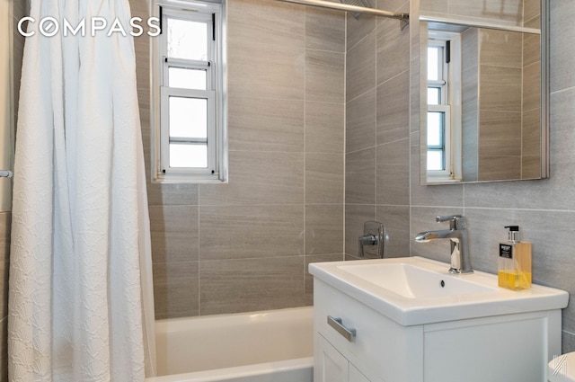bathroom featuring vanity, shower / bath combo, and tile walls