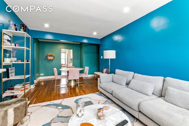 living room featuring baseboards, recessed lighting, and wood finished floors