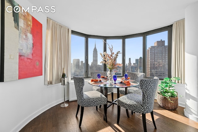330 E 38th St Unit 50E, New York City, NY 10016 - dining area featuring wood-type flooring, baseboards, and a skyline view