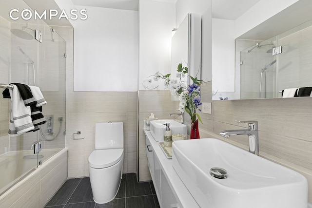 330 E 38th St Unit 50E, New York City, NY 10016 - bathroom with a sink, tile walls, tiled shower / bath, toilet, and tile patterned flooring
