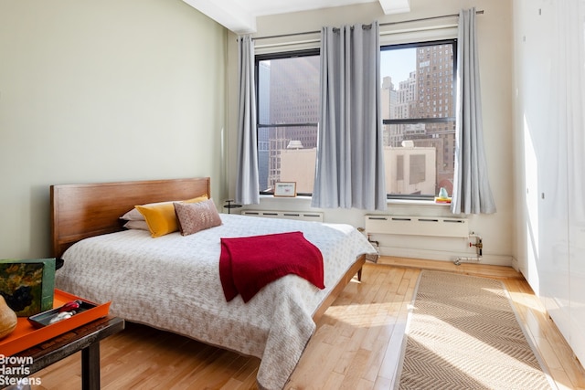 bedroom with wood finished floors and multiple windows