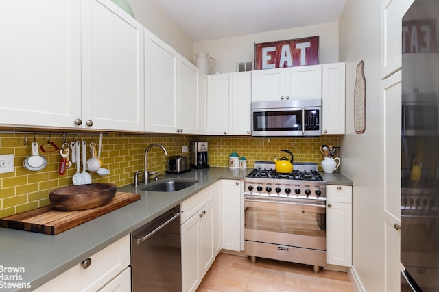 kitchen featuring a sink, appliances with stainless steel finishes, white cabinets, and visible vents