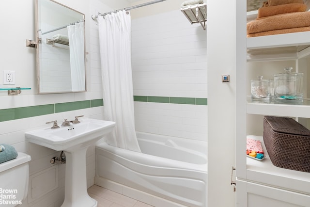 full bath featuring tile patterned floors, toilet, and shower / tub combo with curtain