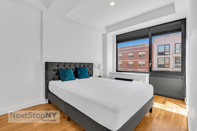 bedroom with wood finished floors, recessed lighting, and baseboards
