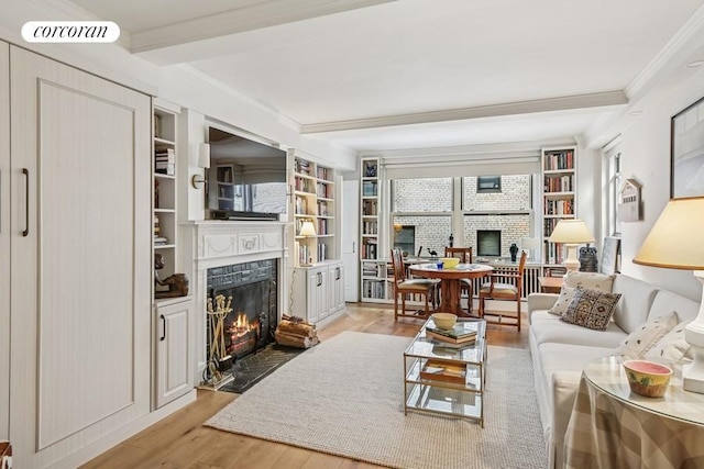living area featuring ornamental molding, beam ceiling, visible vents, a fireplace, and wood finished floors