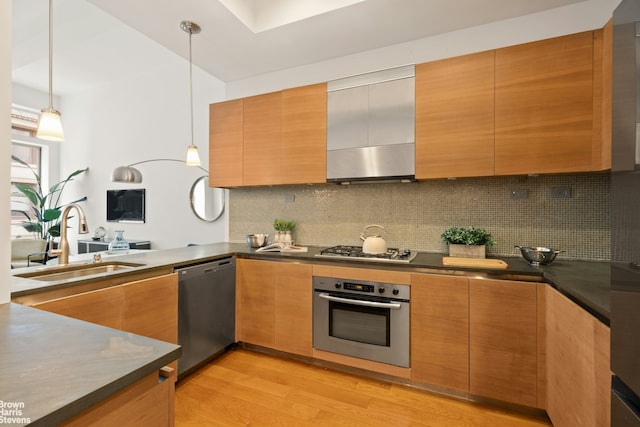 49 E 21st St Unit 2B, New York City, NY 10010 - kitchen featuring stainless steel appliances, a sink, dark countertops, and light wood-style floors