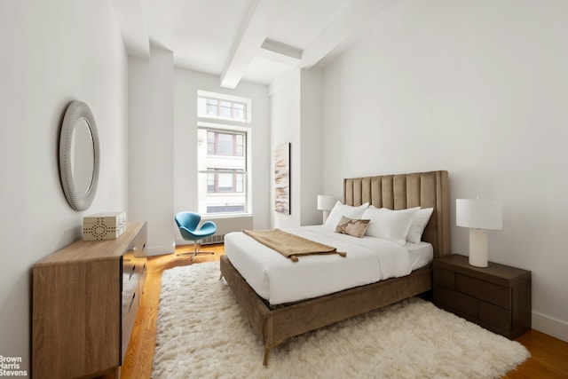 49 E 21st St Unit 2B, New York City, NY 10010 - bedroom featuring beamed ceiling, wood finished floors, and baseboards