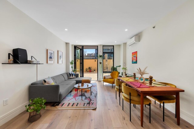 114 Lexington Ave Unit 203, New York City, NY 11238 - living room with expansive windows, light wood-type flooring, a wall unit AC, baseboards, and recessed lighting