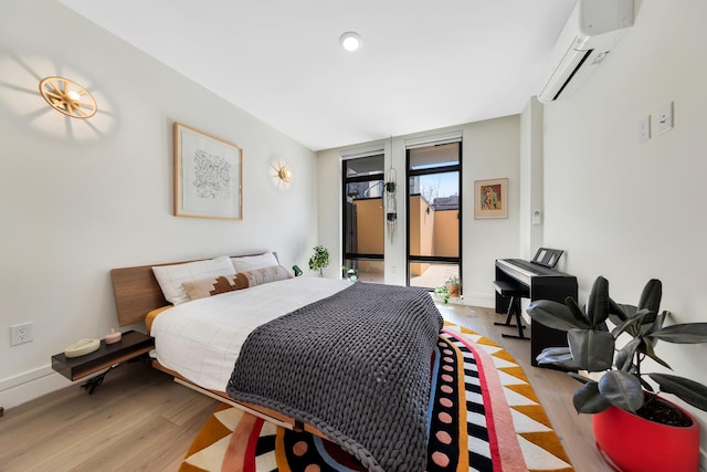 bedroom with light wood finished floors, an AC wall unit, access to outside, and recessed lighting