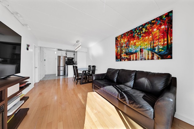 living room with light wood-type flooring and baseboards