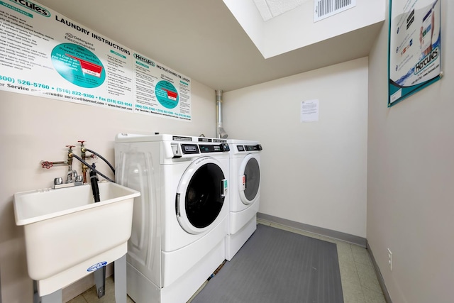 9965 Shore Rd Unit 6C, New York City, NY 11209 - laundry room with washing machine and dryer, a sink, baseboards, and a skylight