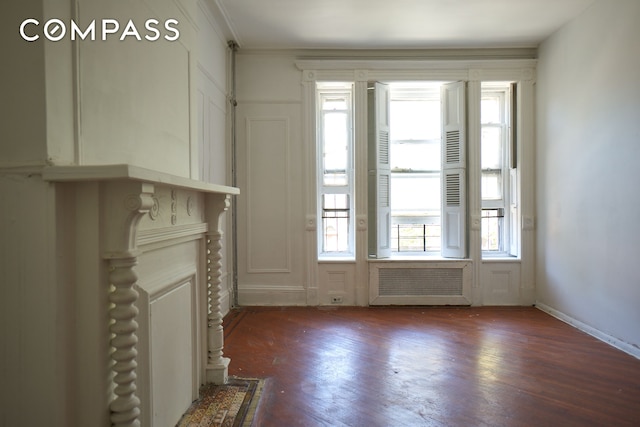 660 Macon St, New York City, NY 11233 - unfurnished living room with radiator, wood finished floors, and ornamental molding