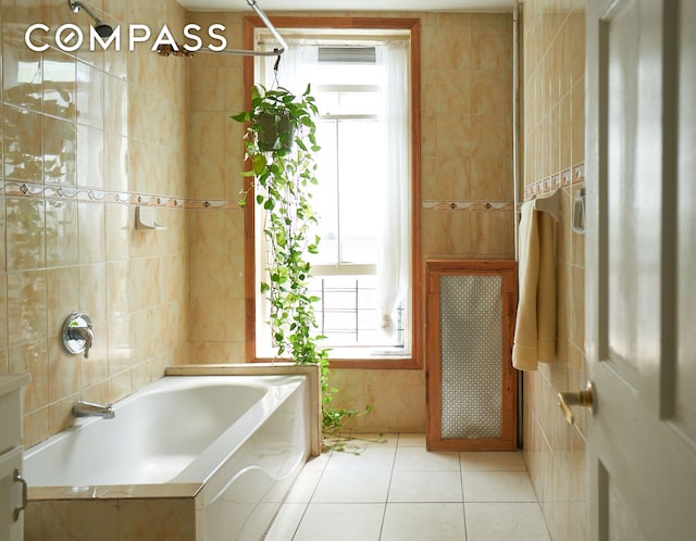 660 Macon St, New York City, NY 11233 - bathroom with tile walls, a bathtub, tile patterned flooring, and a shower