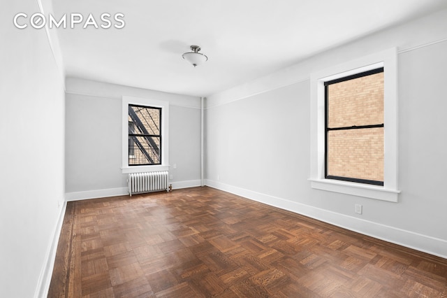 spare room with radiator heating unit and baseboards