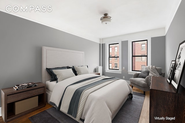 bedroom featuring wood finished floors and radiator