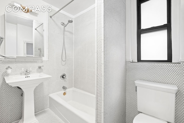full bath featuring shower / bathtub combination, toilet, tile walls, and a sink