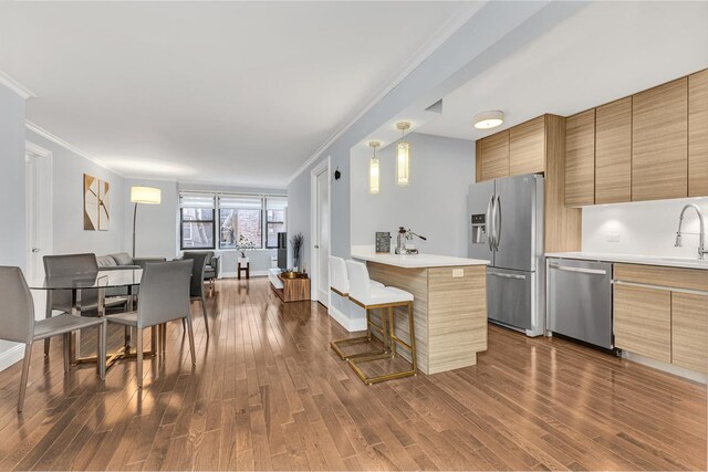 333 E 34th St Unit 2M, New York City, NY 10016 - kitchen featuring appliances with stainless steel finishes, crown molding, dark wood-style floors, and modern cabinets
