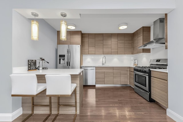 333 E 34th St Unit 2M, New York City, NY 10016 - kitchen with stainless steel appliances, wall chimney range hood, a kitchen breakfast bar, dark wood-type flooring, and light countertops