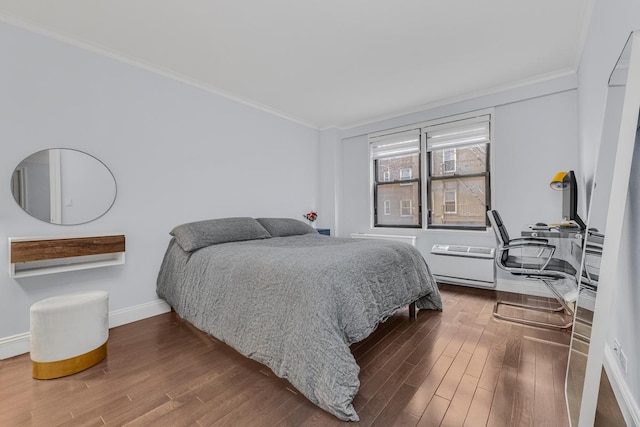 333 E 34th St Unit 2M, New York City, NY 10016 - bedroom featuring crown molding, baseboards, wood finished floors, an office area, and an AC wall unit