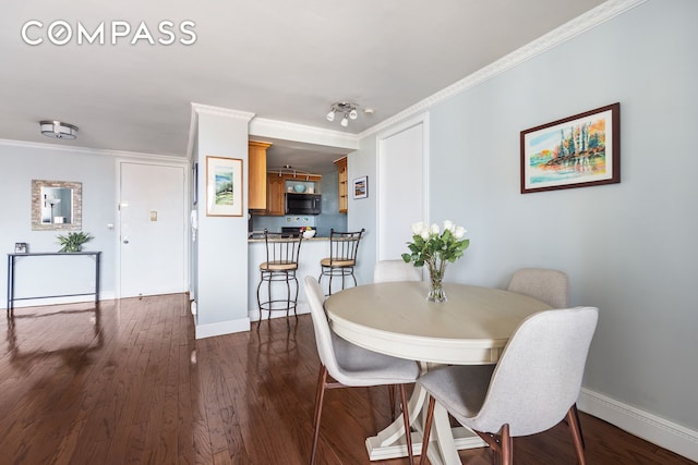 dining room featuring baseboards, ornamental molding, and dark wood-type flooring