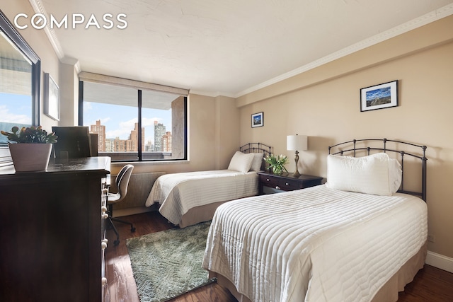 bedroom featuring baseboards, ornamental molding, and wood finished floors