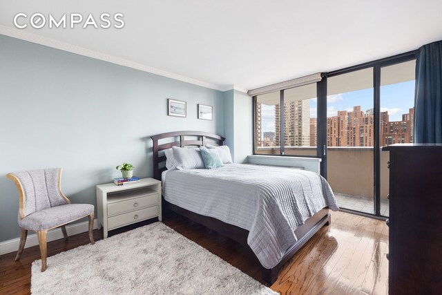 233 E 86th St Phb, Phb, New York City, NY 10028 - bedroom with crown molding, a city view, hardwood / wood-style floors, and baseboards