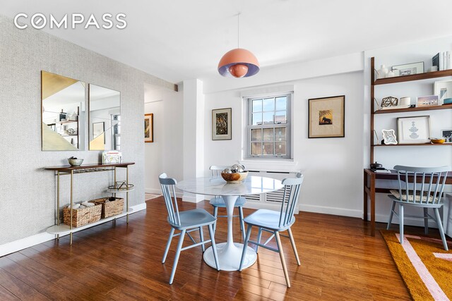 333 E 14th St Unit 10D, New York City, NY 10003 - dining area featuring wood finished floors, baseboards, and wallpapered walls