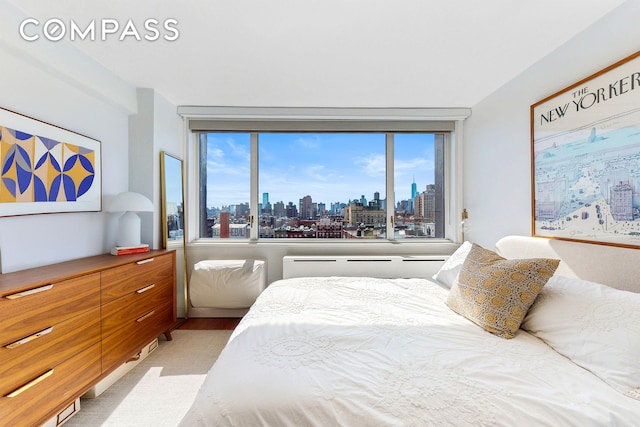 333 E 14th St Unit 10D, New York City, NY 10003 - bedroom featuring a skyline view, multiple windows, and light wood-style floors
