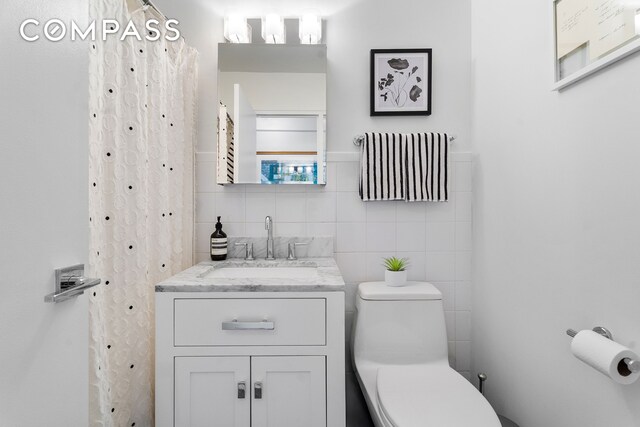 333 E 14th St Unit 10D, New York City, NY 10003 - bathroom featuring tile walls, toilet, and vanity
