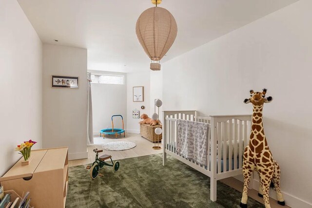 bedroom featuring a crib and baseboards