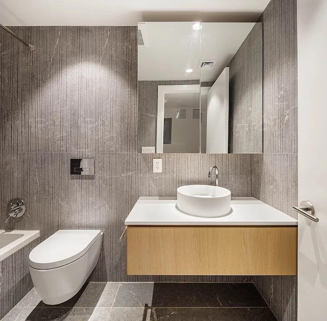 full bath with toilet, tile walls, granite finish floor, visible vents, and vanity