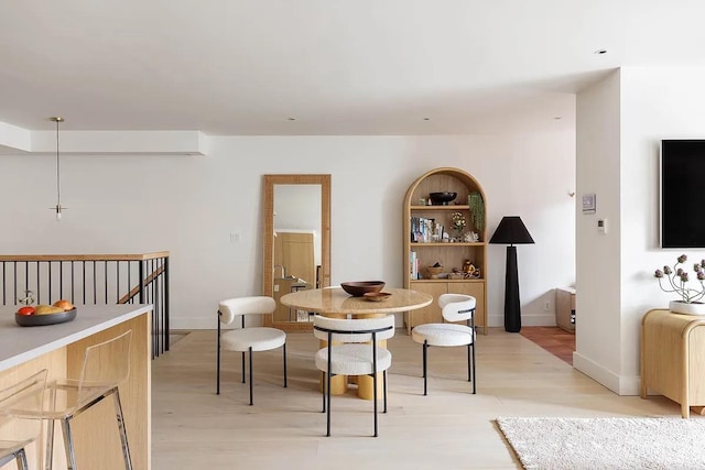 dining room featuring baseboards and light wood finished floors