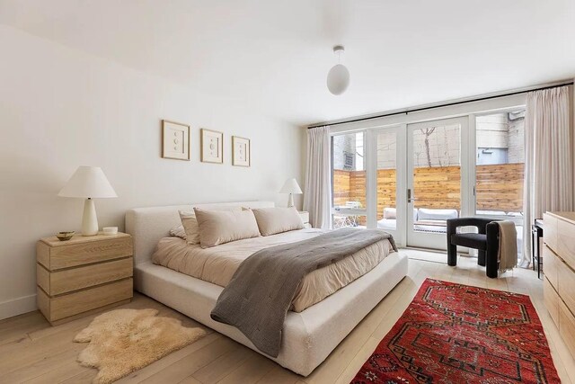 bedroom featuring light wood-style flooring and access to exterior