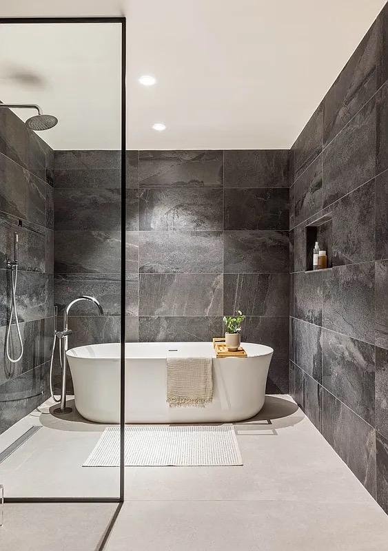 bathroom with tile walls, walk in shower, and a freestanding bath